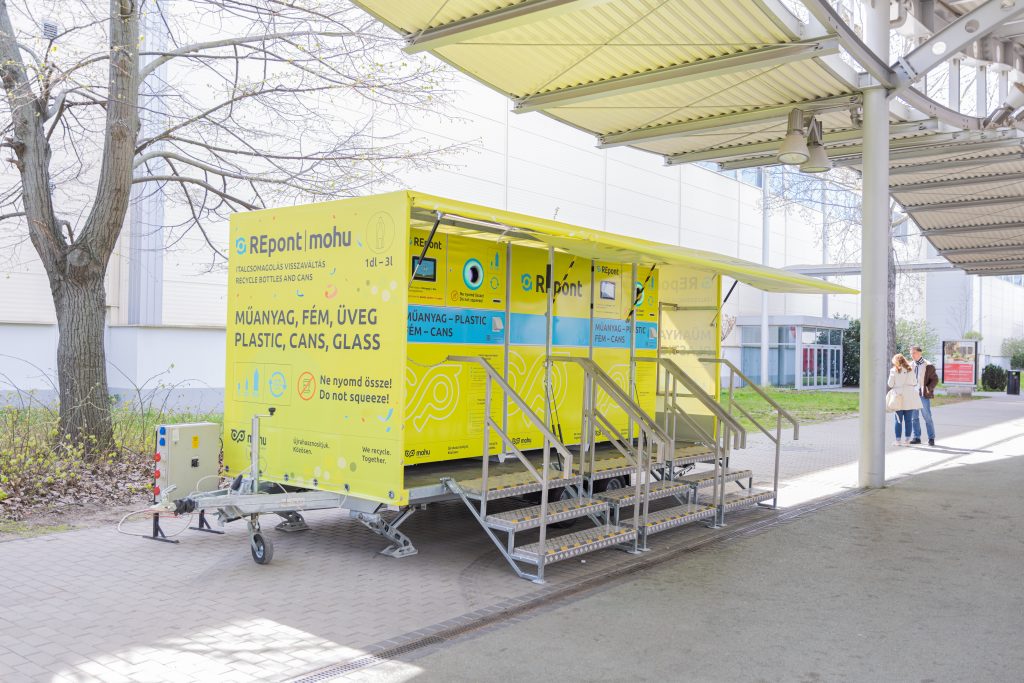 Trailer-mounted festival reverse vending machine installed and ready for operation with integrated canopy, stairs and multiple bottle return stations